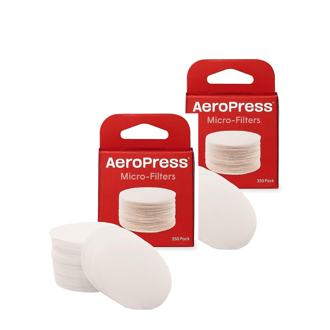 Auf dem Bild sieht man zwei Packungen der AeroPress Papierfilter. Die Filter liegen vor der Verpackung. 